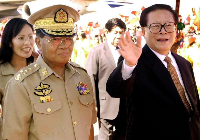 Jiang Zemin, waves as he walks with Senior Gen Than Shwe upon his arrival at Yangon international airport Dec 12, 2001 AP