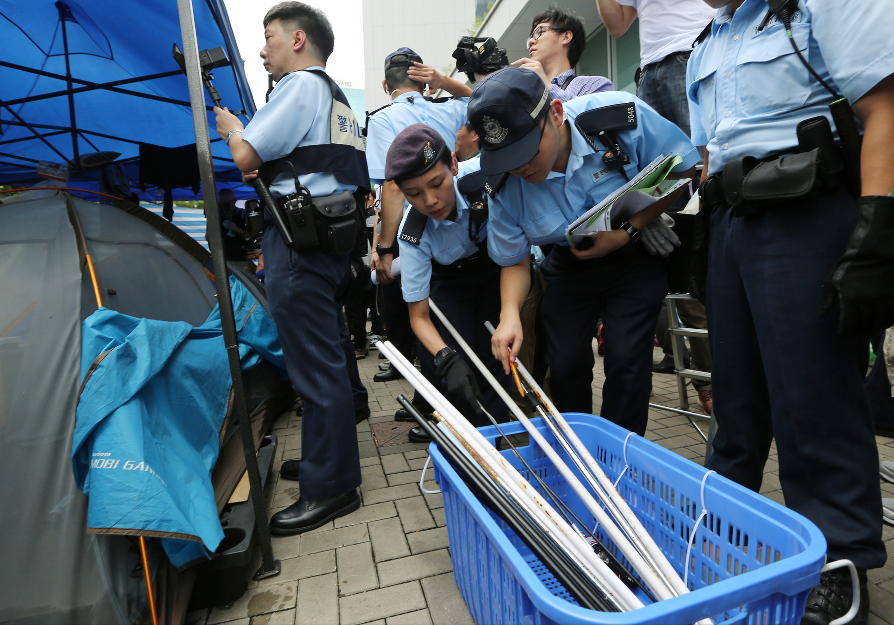 Police remove metal sticks and other items they deem could be used for harm as they inspect protesters’ tents pitched outside Legco in Admiralty on June 13, 2015.