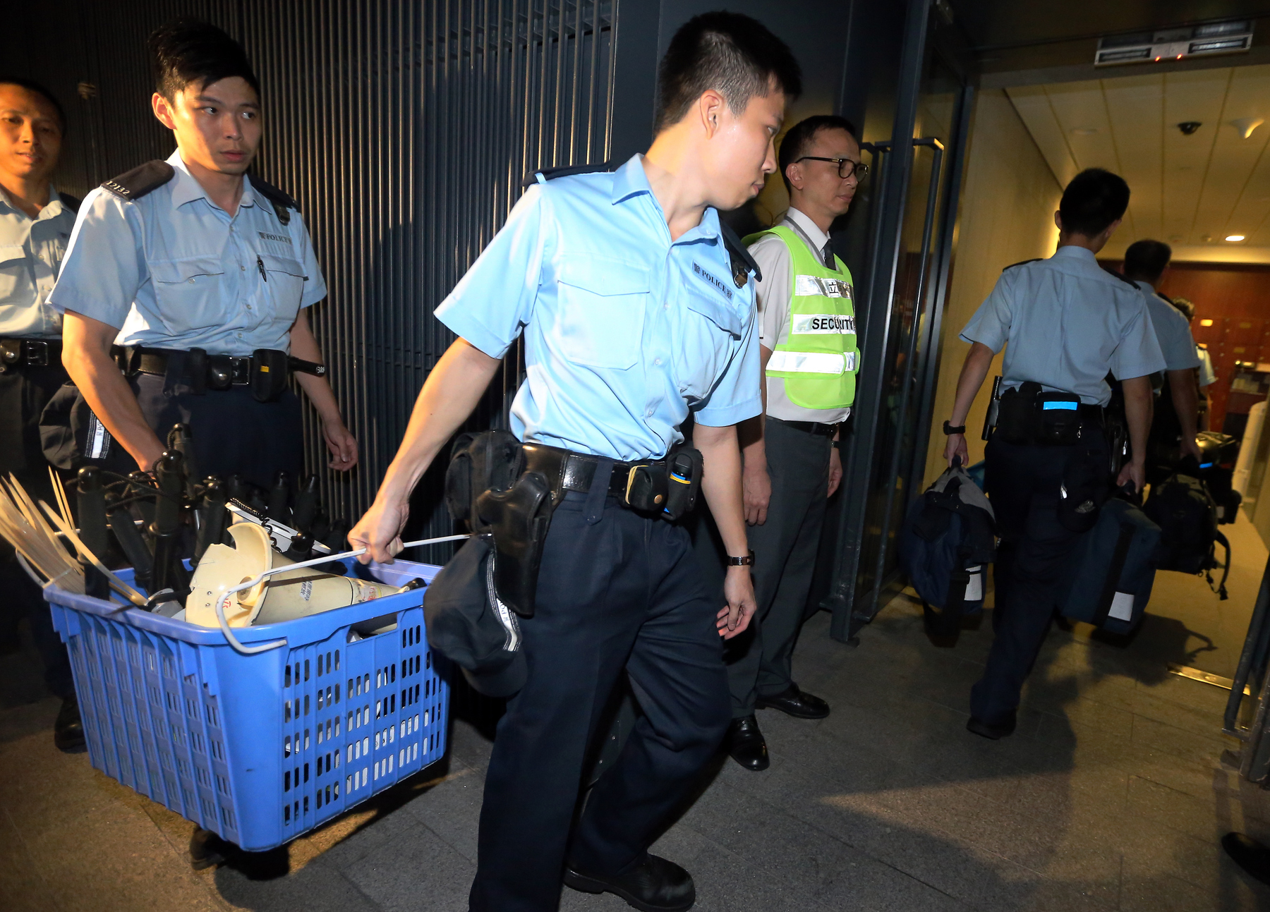 Officers carry equipment inside the Tamar complex in Admiralty on June 16, 2015. Some 200 police officers were deployed to the site after the Legco president agreed to the police’s proposal to enhance security at the government headquarters.